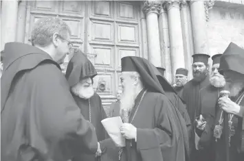  ?? AGENCE FRANCE PRESSE ?? Greek Orthodox Patriarch of Jerusalem Theophilos III delivers a statement to the press as he stands next to the Custodian of the Holy Land Fr. Francesco Patton and Armenian Bishop Siwan (left) as they stand outside the closed doors of the Church of the Holy Sepulchre in Jerusalem’s Old City.