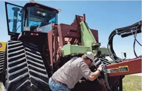  ?? BRIAN BRAINERD/THE DENVER POST VIA AP FILE ?? Lawmakers in several states have introduced bills that would force farming equipment manufactur­ers to provide the tools, software, parts and manuals needed for farmers to do their own repairs.