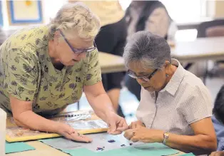 ?? ADOLPHE PIERRE-LOUIS/JOURNAL ?? Nellie Lang, left, and Andreita Cordero work on a pair of earrings made with fused glass at the Manzano Mesa Multigener­ational Center.