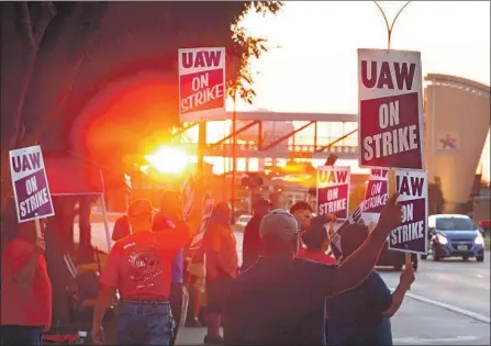  ?? Larry W. Smith EPA/Shuttersto­ck ?? UNITED Auto Workers members picket outside the GM plant in Arlington, Texas, on Tuesday. The strike involves 49,000 workers.