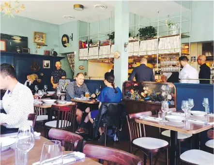  ??  ?? The dining room at St. Lawrence features photos from chef/owner J.C. Poirier’s childhood.