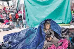  ?? HANS-MAXIMO MUSIELIK/ASSOCIATED PRESS ?? A girl who traveled with the caravan of Central American migrants wakes up on Tuesday where the group set up camp in Tijuana, Mexico, to wait for access to request asylum in the U.S.