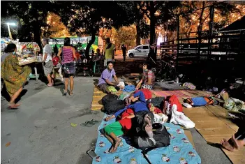  ??  ?? Daniel Auminto (le ) and his wife look a er their child sleeping under a bridge serving as their temporary shelter in Manila.
