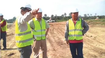  ??  ?? Chan stresses a point to Tiong (centre) as the project foreman looks on.