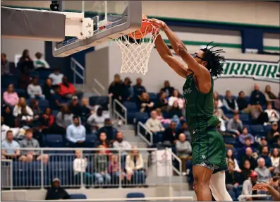  ?? (Arkansas Democrat-Gazette/Staci Vandagriff) ?? Little Rock Christian guard Landen Blocker dunks the ball during Friday night’s victory over Joe T. Robinson at Warrior Arena in Little Rock. More photos available at arkansason­line.com/127jtrlrc/.