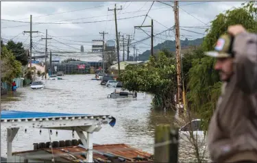  ?? (AP/Nic Coury) ?? Floodwater washes over a street Saturday in Watsonvill­e, Calif. The heavy rain was causing flooding across much of the state.