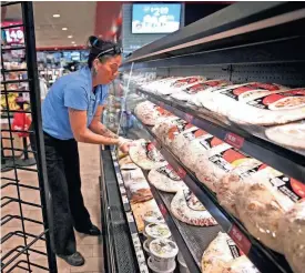  ?? ?? Nancy Rodriguez, an assistant food service leader, stocks food items at the Kwik Trip at 2807 River Valley Road in Waukesha. Kwik Trip has added more than 150 locations in the past four years.