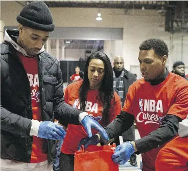 ?? CHRIS YOUNG / THE CANADIAN PRESS ?? Toronto Raptors DeMar DeRozan, left, and teammate Kyle Lowry and their families sort food donations on Friday at the Daily Bread Food Bank in Toronto.