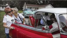  ?? MIKE CARDEW PHOTOS / AKRON BEACON JOURNAL ?? Gale Williams (left) gets a kiss from daughter Lisa Ware, one of her four children, before getting into a 1953 Chevrolet Bel Air at her Munroe Falls home for a memorial cruise-in for her late husband on Sunday.