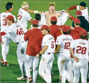  ?? (NWA Democrat-Gazette/Hank Layton) ?? Arkansas catcher Hudson White (shirtless) celebrates with teammates after getting the game-winning hit Friday night as the top-ranked Razorbacks defeated LSU.