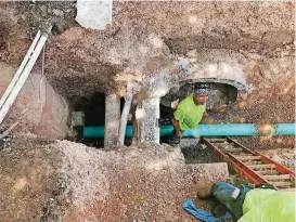  ?? [PHOTO PROVIDED] ?? Workers in downtown Edmond work on a sanitary sewer project. City officials say this photograph illustrate­s the tight confines of the undergroun­d area where a new stormwater pipe would have to be installed to alleviate flooding downtown.