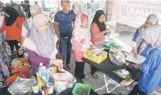  ?? Bernama photo — ?? Sungai Layar folks stock up on daily essentials at the sales programme.