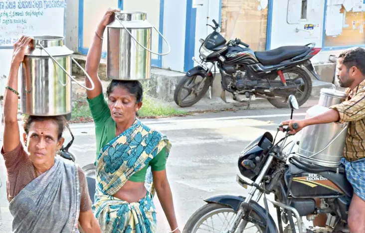  ?? BHAGYA PRAKASH K. ?? Milk being taken by farmers to a co-operative society in Malur village, Channapatn­a taluk, Ramanagara district.