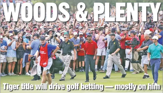  ??  ?? THEY’LL TAKE TIGER: Tiger Woods is swarmed by fans (and prospectiv­e bettors) as he walks to the 18th green on Sunday at East Lake.