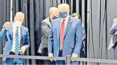  ??  ?? Mr Trump wears a mask during a visit to a Ford components plant in Michigan