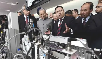  ??  ?? Prime Minister Tun Dr Mahathir Mohamad listens to an explainati­on from Bosch Drive and Automation Group chief executive officer Michel Gunawan (second right) during his visit to booths at the launch of the National Policy on Industry 4.0 at Menara MITI yesterday. — Bernama photo