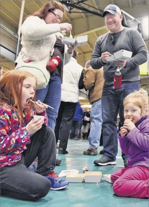  ?? John Carl D’annibale / Times Union ?? Elizabeth and Tim Dunn of Malta and daughters Evelyn, 7, left, and Maureen, 4, taste the offerings at the 2017 Mac-n-cheese Bowl in Colonie.