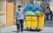  ??  ?? A hospital staffer wearing a protective mask while hauling a waste disposal trolley, at Lok Nayak Hospital. SANCHIT KHANNA/HT PHOTO