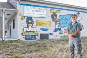  ?? STAFF PHOTO BY TIM BARBER ?? Walter Dix, owner of Allied Glass and Mirror in Rossville, stands in front of a mural painted on the side of his building facing Mack Smith Road.