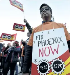  ?? THE CANADIAN PRESS FILES ?? Public servants protest over problems with the Phoenix pay system outside the Office of the Prime Minister and Privy Council in Ottawa on Thursday, Oct. 12, 2017. The federal government says it’s now taking more than six months, on average, to transfer...