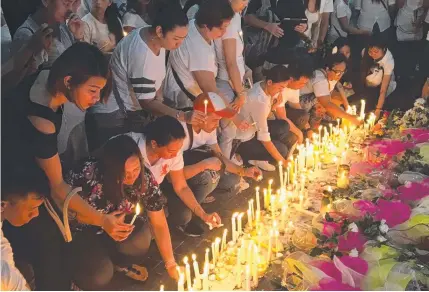  ?? Picture: AP ?? TOUCHING SCENE: Mourners at a memorial outside the Resorts World Manila entertainm­ent complex.