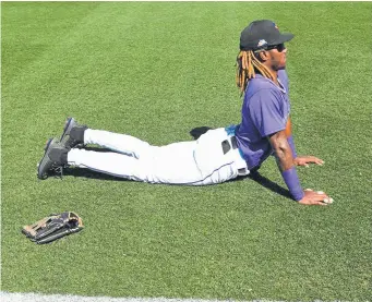  ?? Photos by RJ Sangosti, The Denver Post ?? Rockies outfielder Raimel Tapia, from the Dominican Republic, stretches during spring training. Tapia is one of a number of Latino players on the spring roster.