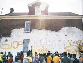  ?? Haley Nelson/Post-Gazette ?? Members of Moving the Lives of Kids’ Community Mural Project begin work Tuesday on a new mural in Homewood to protest gun violence.