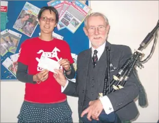  ??  ?? Robin Webster, secretary of St John Perth and Kinross, presented a cheque for £1,095.69 for Rachel House, Kinross, to Rachel Cheer of the Children’s Hospice Associatio­n Scotland. The money was collected over the summer from volunteer pipers in support...