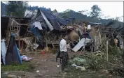  ?? THE ASSOCIATED PRESS ?? A man looks at homes destroyed after air and artillery strikes in a displaceme­nt camp in Laiza, Myanmar, on Oct. 10.