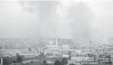  ??  ?? Smoke billows from the former rebel-held district of Bustan al-Qasr in Aleppo. — AFP photos