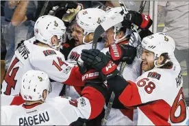  ?? MICHAEL DWYER / AP ?? The Senators surround Clarke MacArthur (center) after he scored the series-clinching goal in overtime of Sunday’s Game 6 win over the Bruins in Boston.