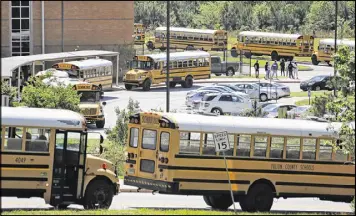  ?? BOB ANDRES /BANDRES@AJC.COM ?? Buses line up at Langston Hughes High School as school lets out Tuesday. Four Langston Hughes students were killed and another was injured Monday in a crash involving a tractor-trailer and a Lincoln Navigator in South Fulton.