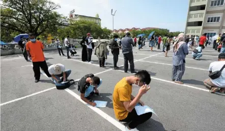  ??  ?? Doing their part: Foreign workers filling up forms to get inoculated at PPV Midlands in Shah alam. — SS Kanesan/the Star