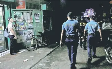  ??  ?? Policemen from Caloocan Police District patrol a dimly lit alley at a residentia­l district in Caloocan City Metro Manila Philippine­s. — Reuters photo