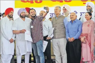  ?? ANIL DAYAL/HT ?? A man who received a job letter takes a selfie with CM Capt Amarinder Singh and technical education minister Charanjit Singh Channi while (from right) ministers Manpreet Badal, Aruna Chaudhary and Brahm Mohindra, and state Congress chief Sunil Jakhar...