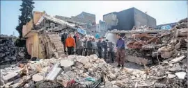  ?? Marcus Yam Los Angeles Times ?? RESIDENTS gather to remove corpses trapped in the rubble of a home destroyed by reported coalition airstrikes in west Mosul’s Jadidah neighborho­od.