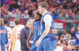  ?? ASSOCIATED PRESS ?? Dallas Mavericks guard Luka Doncic hugs guard Kyrie Irving (11) during Thursday’s game against the Atlanta Hawks in Dallas. The Mavericks have won 14 of their past 16 games.
