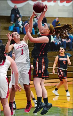  ?? SARAH GORDON/THE DAY ?? Montville’s Emily Meigs is challenged by St. Bernard’s Briana Beverly (1) at the basket during the Indians’ 46-32 victory over the Saints on Saturday afternoon at St. Bernard School. Visit www.theday.com to view a photo gallery.