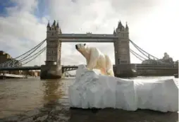  ?? OLI SCARFF/GETTY IMAGES ?? Reports of a new ice age on the River Thames were false — like this polar bear sculpture meant to draw attention to climate change near Tower Bridge.