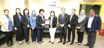  ?? ?? Adeline Leong (fifth from right) presenting a memento to Ng Kiat Min.