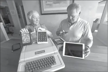  ?? Elaine Thompson/AP ?? Technology: Kathy and Steve Dennis display several of their own cell phones and computer tablets along with their 1980's-era Apple II+ computer bought for their then young sons in Bellevue, Wash. Three decades ago they never heard the phrase "screen time," nor did they worry much about limiting the time the kids spent with technology, considerin­g the computer an investment in their future. Things have changed with their grandkids and their phones.