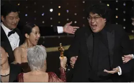  ?? CHRIS PIZZELLO — THE ASSOCIATED PRESS ?? Bong Joon Ho, right, reacts as he is presented with the award for best picture the Oscars on Sunday in Los Angeles.