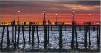  ?? Jay L. Clendenin Los Angeles Times ?? AFTER AN afternoon of shopping and dining, stop to enjoy the sunset at the Redondo Beach Pier.