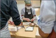  ?? (For The Washington Post/Taro Karibe) ?? Students work as a team in a Better Home cooking class for men in Tokyo. Husbands once spooked by the old Japanese saying, “Danshi-chubo-ni-hairazu,” or “men should be ashamed to be found in the kitchen,” are now eager to learn.