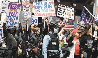 ?? Nam Y. Huh / Associated Press ?? Protesters rally against stayathome restrictio­ns in Illinois outside a tower in central Chicago where Gov. J.B. Pritzker, a Democrat, and other state officials have offices.