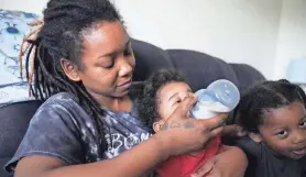  ?? JOHN BAZEMORE/AP ?? Ashley Yancey feeds her 11-month-old daughter Olivia as 2-year-old Oliver Tolvert looks on at right in Douglasvil­le, Ga.