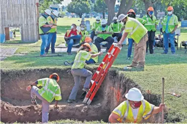  ?? [AP FILE PHOTO] ?? Workers climb out of the excavation site on July 14 at a potential unmarked mass grave from the 1921 Tulsa Race Massacre at Oaklawn Cemetery in Tulsa. A second excavation is to begin Monday in an effort to find and identify victims.