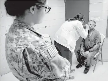  ?? Bob Owen photos / San Antonio Express-News ?? Leonel Presas, right, has his eyes checked Tuesday by Brenda Amaya of the Texas A&M Health Science Center during a traveling clinic at the El Cenizo Community Center in El Cenizo.