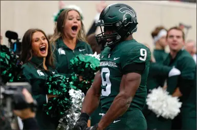  ?? (AP/Al Goldis) ?? Michigan State running back Kenneth Walker celebrates after scoring a touchdown Saturday during the No. 8 Spartans’ 37-33 victory over the No. 6 Michigan Wolverines at Spartan Stadium in East Lansing, Mich. Walker, a Wake Forest transfer, ran for 197 yards and five touchdowns.