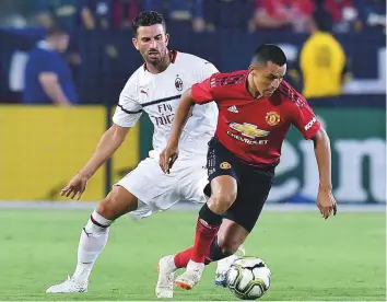 ?? AFP ?? Manchester United’s Alexis Sanchez (right) drives past AC Milan defender Mateo Musacchio during the Internatio­nal Champions Cup match in Carson, California, on Wednesday.